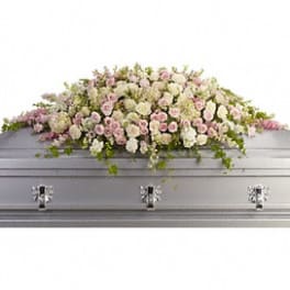 Pink and white floral casket spray on a gray casket