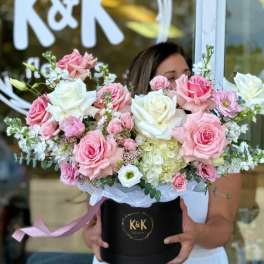 Large pink and white rose arrangement in a black hat box