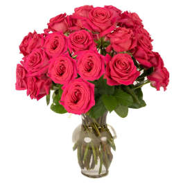 Arrangement of bright pink roses in a clear glass vase with visible stems