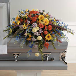 Colorful floral spray on a silver casket
