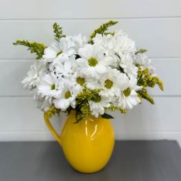 White daisy bouquet in a yellow pitcher vase