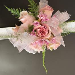 Pink rose bouquet with ribbon and greenery on a white handle
