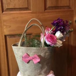 Pink and white roses with purple flowers in a burlap tote bag
