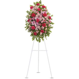 Tall pink and fuchsia standing floral spray on a white easel