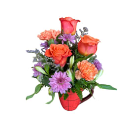 Bouquet of orange roses, purple daisies, and carnations in a red mug