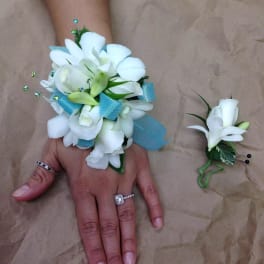 White floral wrist corsage and boutonniere with blue ribbon