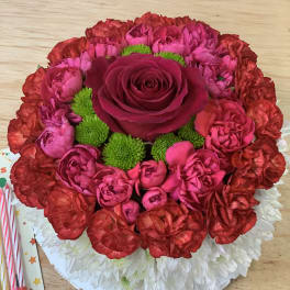 Round bouquet of red and pink flowers with a central rose