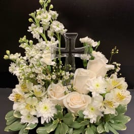 White floral arrangement with a clear cross centerpiece