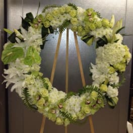 Large floral wreath of white and pale green flowers on an easel