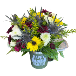 Mixed bouquet in a green mug with "Happy Camper" text