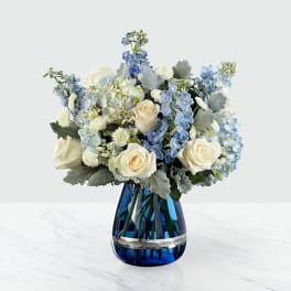 Blue and white flower arrangement in a cobalt glass vase