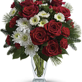 Red roses and white daisies in a clear glass vase