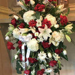 Large standing spray of red and white flowers on an easel