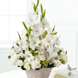 White floral arrangement in a woven basket with tall blooms