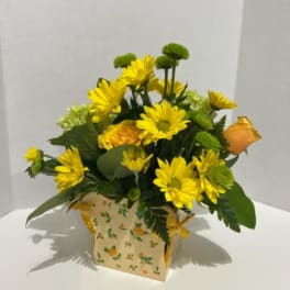 Yellow daisy bouquet in a floral paper box