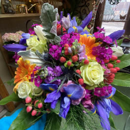 Colorful mixed bouquet with roses, gerbera daisies, and purple irises