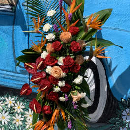 Tropical floral arrangement with red roses and orange bird-of-paradise flowers