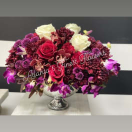 Red, white, and purple floral arrangement in a silver pedestal vase