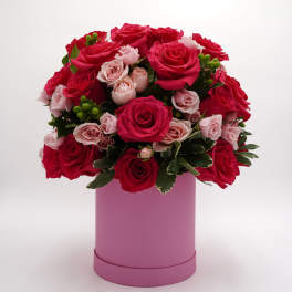 Bouquet of red and pale pink roses in a pink box