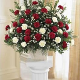 Large red and white floral spray on a pedestal stand