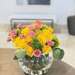 Yellow and pink rose bouquet in a clear glass vase