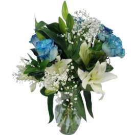 Bouquet of white lilies and blue-tinted roses in a glass vase