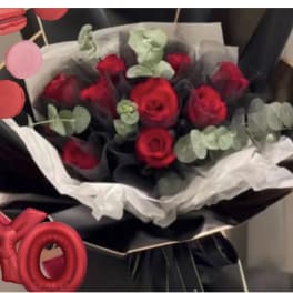 Bouquet of red roses wrapped in black and white paper