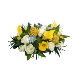 Yellow calla lilies and white roses in a low bouquet