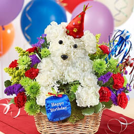 White teddy bear floral arrangement in a basket with birthday decorations
