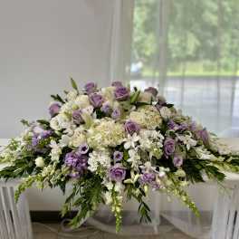 Lavender and white floral arrangement spread across a table