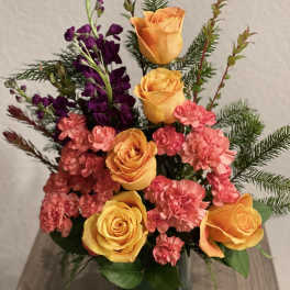 Orange roses and pink carnations in a glass vase