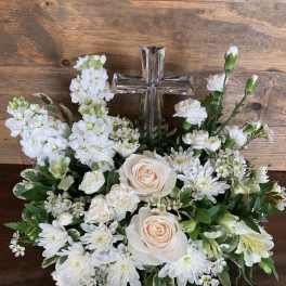 White floral arrangement with a silver cross centerpiece