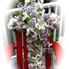 Lavender and white floral cross arrangement on a red chair