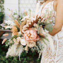 Bride holding a large peach and white bouquet