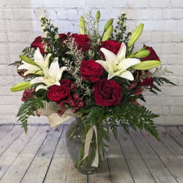 Bouquet of red roses and white lilies in a glass vase