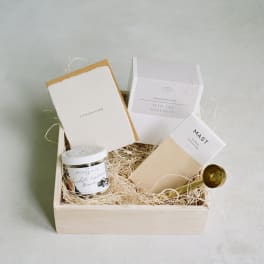 Gift box with coffee and chocolate items in a wooden tray