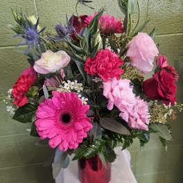 Mixed bouquet of pink and red flowers in a red vase