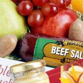 Gift basket with fruit, beef sausage, and a jar of preserves