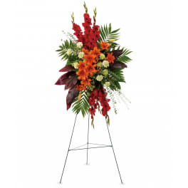 Tall standing spray of red and orange flowers with pale green blooms on a metal easel.