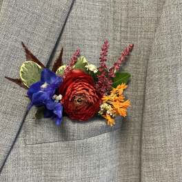 Colorful boutonniere pinned to a gray suit jacket