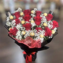 Bouquet of red roses with gold-wrapped chocolates and white baby's breath