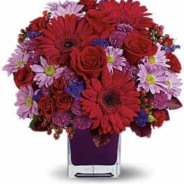 Red and lavender mixed bouquet in a clear square vase