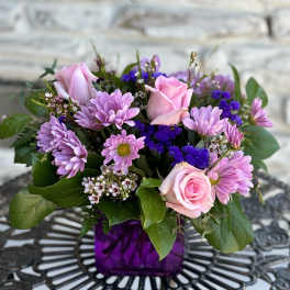 Pink roses and lavender daisies in a purple vase