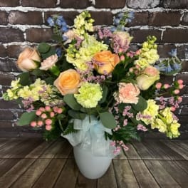 Mixed pastel flower arrangement in a white vase