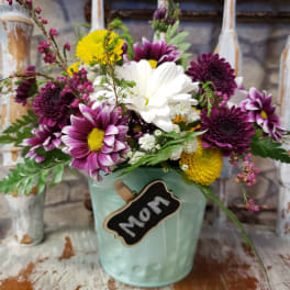 Mixed bouquet in a mint bucket with a "Mom" tag