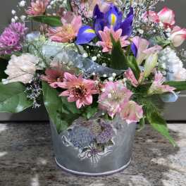 Mixed bouquet in a decorative tin bucket with a "Happy" topper