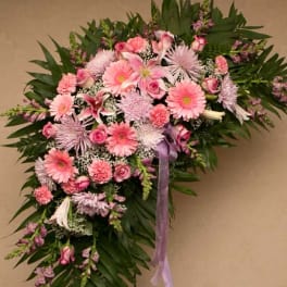 Pink and lavender floral spray with ribbon on a wall display