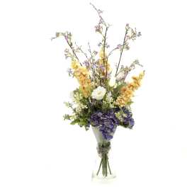 Tall bouquet of purple and yellow flowers in a clear glass vase