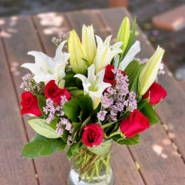 Bouquet of red roses and white lilies in a glass vase