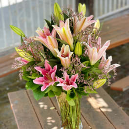 Pink and white lilies in a clear glass vase